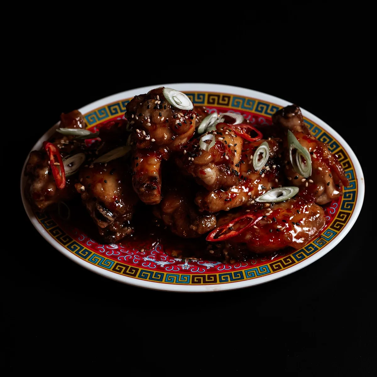 Alitas glaseadas servidas en plato de NERO