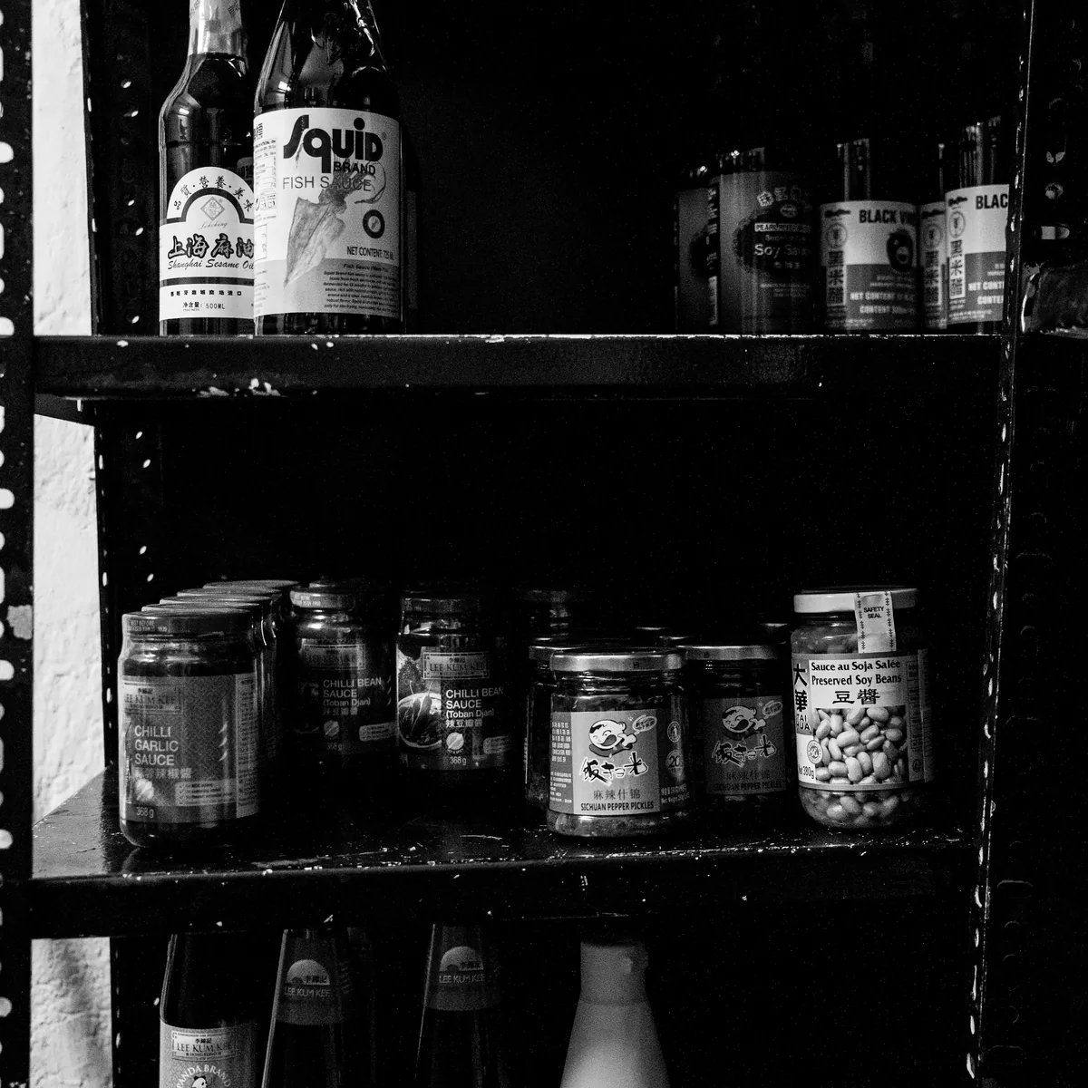 Estanteria con botellas y conservas de la cocina de NERO