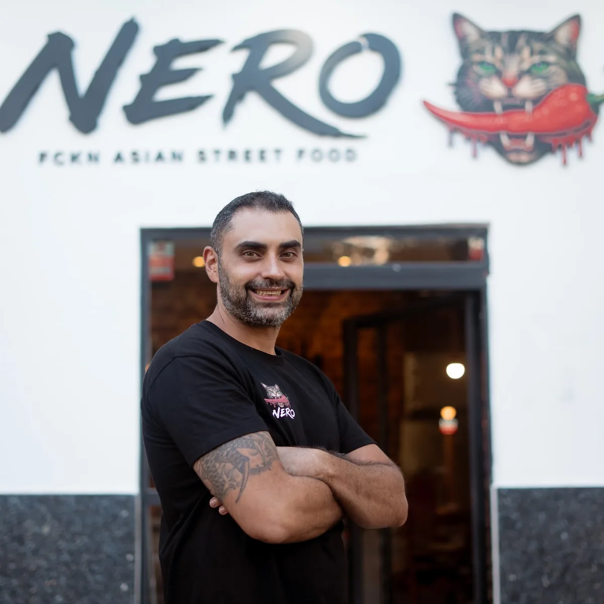 Sam Farahpour en la puerta de NERO, bajo el rotulo del restaurante